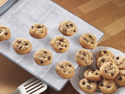 cookies sliding off a parchment lined baking sheet