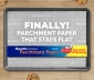 Reynolds Stay Flat Parchment Paper box sitting on top of a parchment lined baking sheet surrounded by cookies