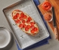 Pepperoni pizza lying on top of a parchment lined baking sheet