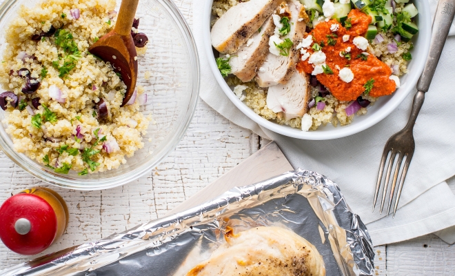 A quinoa bowl on a table and chicken