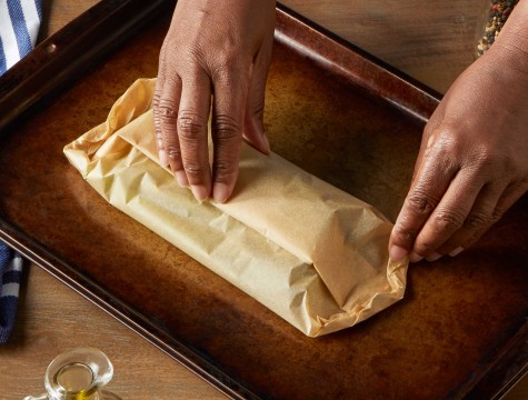 Hands preparing food for the oven