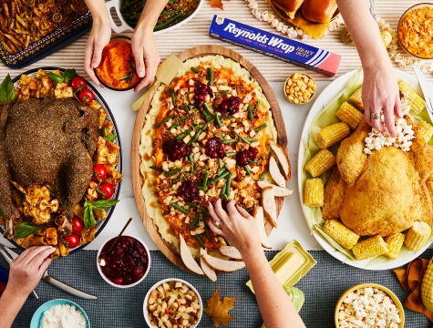 Three turkey plates on a table with reynolds wrap heavy duty foil nearby.