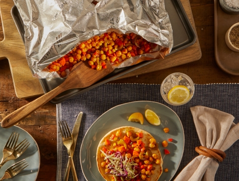 Crunchy BBQ Chickpea & Vegetable Pita Wrap sitting on a plate alongside an open Reynolds Grill Bag with remaining servings inside