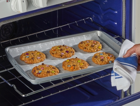 cookies on baking sheet being taken out of an oven