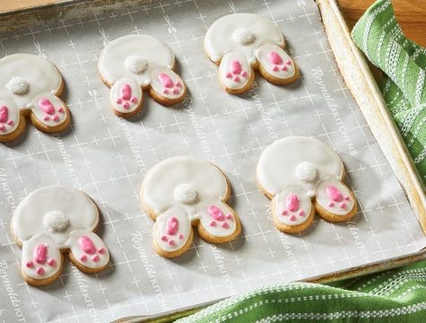 Bunny shaped cookies sitting on a parchment lined baking sheet
