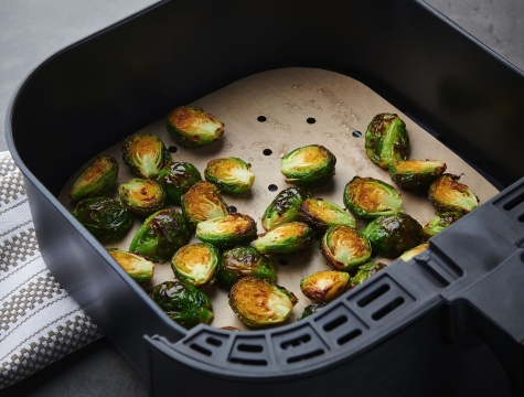 brussels sprouts on a parchment lined air fryer basket