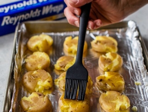 Pakrika smashed potatoes on a foil lined baking pan