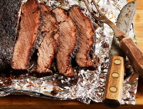 sliced brisket sitting on a sheet of foil