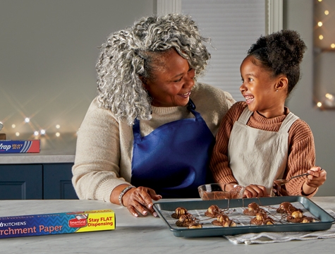 Grandma and granddaughter in a kitchen baking peanut butter chocolate brownie cookies