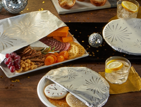 Various plates of NYE themed food partially wrapped in foil