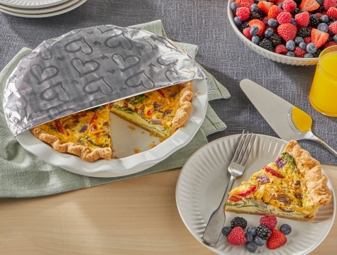 Vegetable quiche partially covered by a sheet of Reynolds Wrap Fun Foil with embossed heart pattern