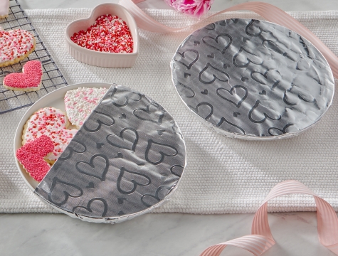heart shaped sugar cooking on a plate partially wrapped by a sheet of Reynolds Wrap Fun Foil with embossed heart pattern