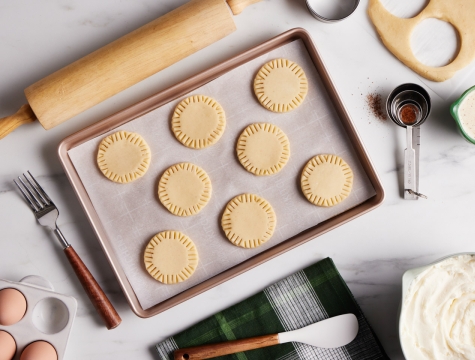 Round cookie dough sitting on a parchment lined baking sheet
