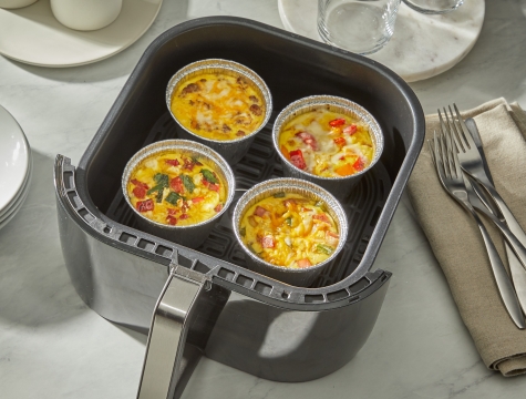 individual egg cups in air fryer cups sitting in an air fryer basket