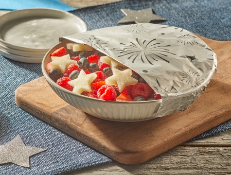 red, white and blue patriotic fruit salad partially covered with a sheet of Reynolds Wrap Fun Foil embossed with fireworks pattern