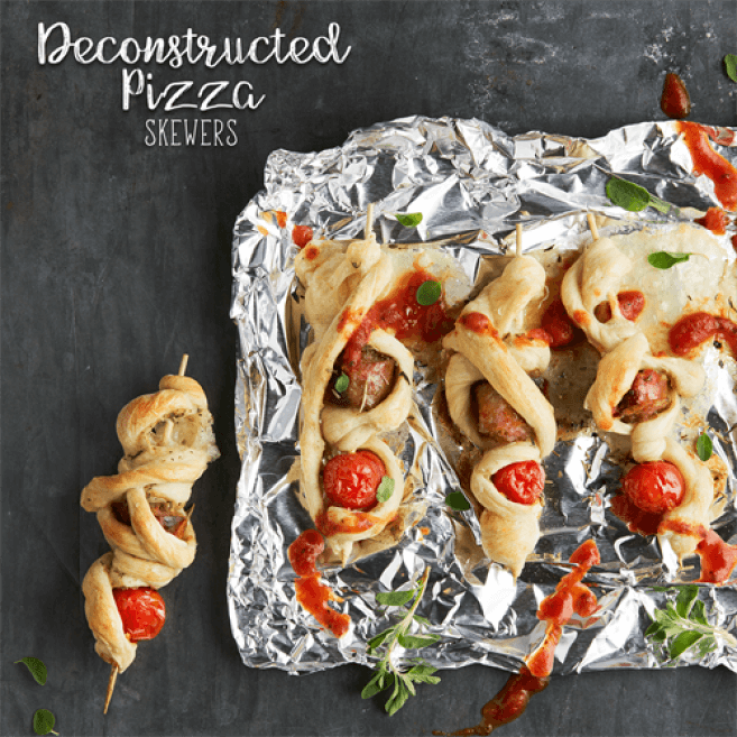 Skewers threaded with tomato, mozzarella cheese and sausage, wrapped in braided pizza dough that is topped with marinara sauce and basil.