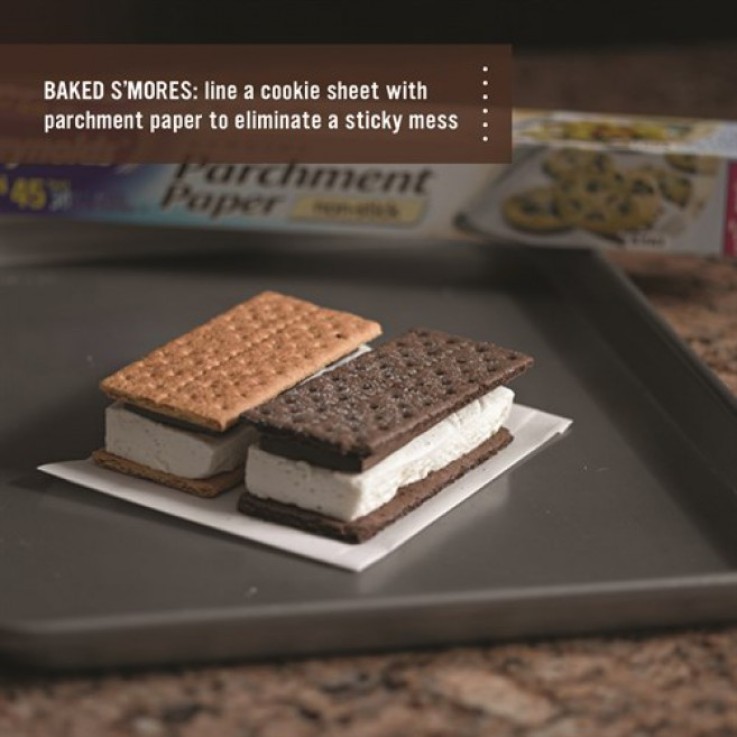 Smores sitting on parchment paper on a cookie sheet.