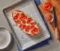 Pepperoni pizza lying on top of a parchment lined baking sheet
