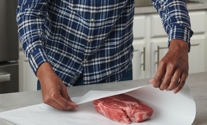 Man wrapping meat in freezer paper