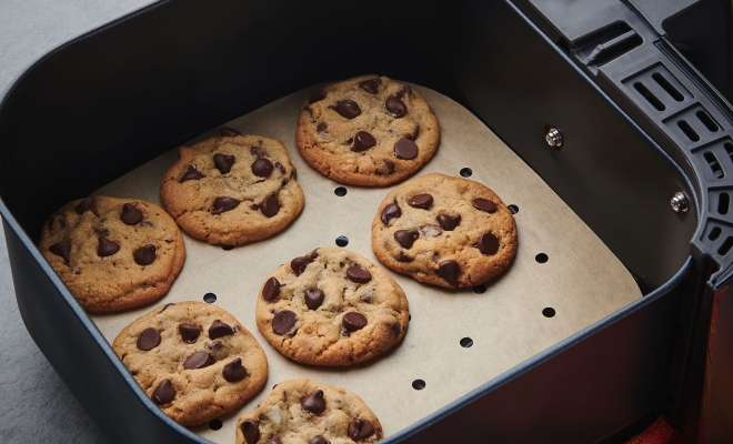 Baked cookies sitting on an air fryer liner in an air fryer
