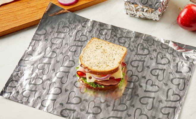Sandwich laying on a sheet of Reynolds Wrap Fun Foil with embossed heart pattern