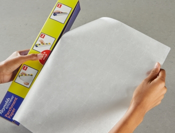 Person tearing parchment paper from box
