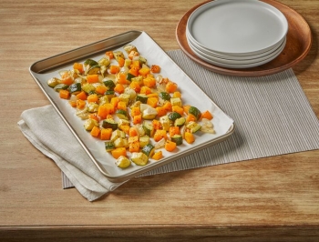 Roasted squash, zucchini and squash on a parchment lined baking sheet