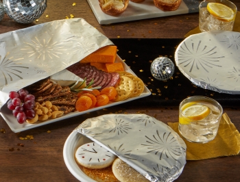 Various plates of NYE themed food partially wrapped in foil
