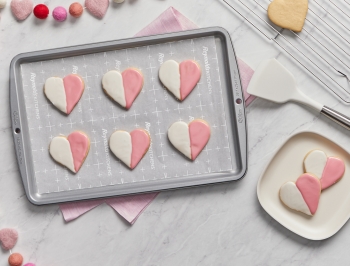 heart shaped sugar cookies on a parchment lined baking sheet