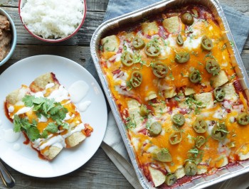 a baking tray and a plate with enchiladas on the table