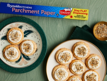 Everything Butter Cookies on plates next to a box of parchment paper
